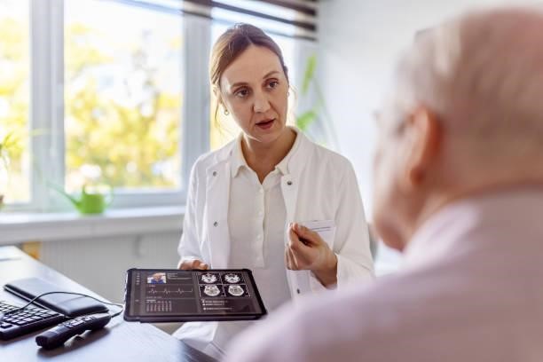 Doctor discussing cancer scan results with elderly patient during second opinion.