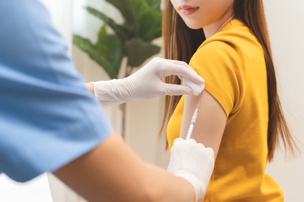 A patient receiving an HPV vaccination in the arm to prevent HPV and cancer, illustrating professional medical immunization services.